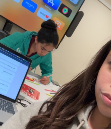 Parnaz drawing, caught in the background of a friend's selfie