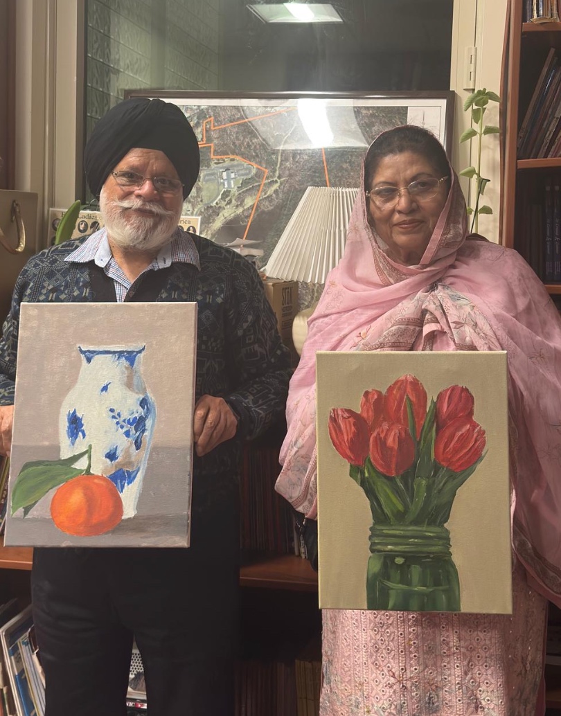 Two students holding the paintings they made in class