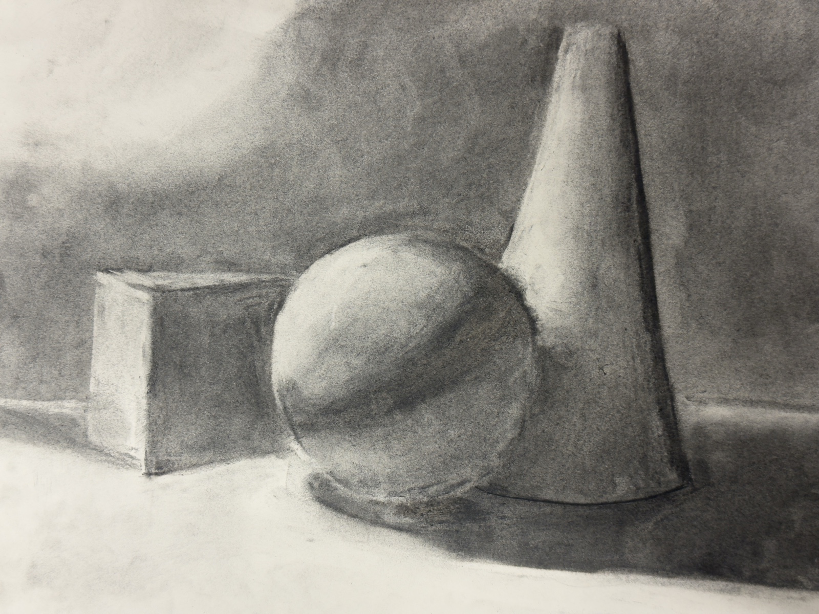 An early charcoal still life of a cube, sphere and cone