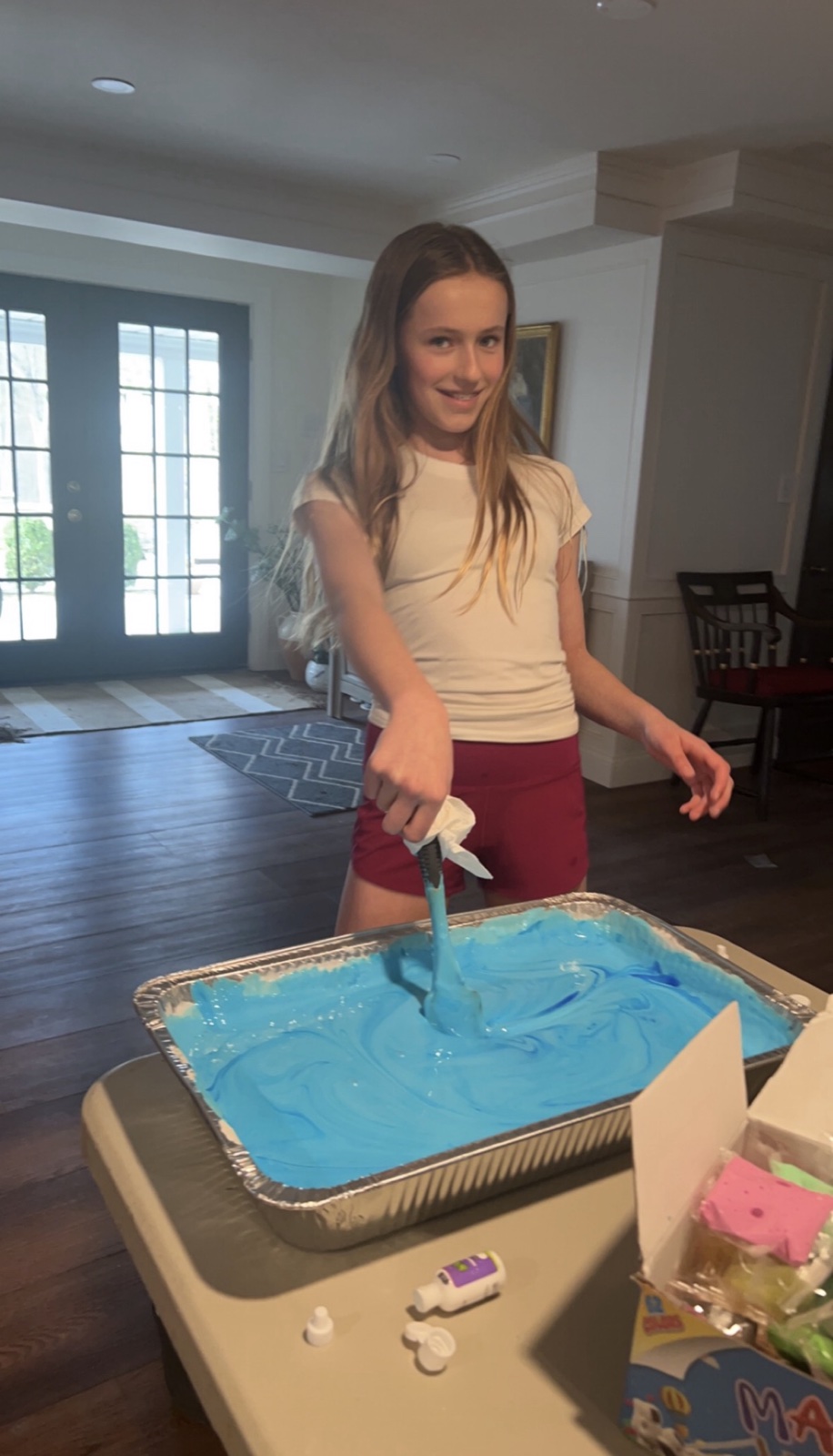 A friend mixing blue slime for the fundraiser