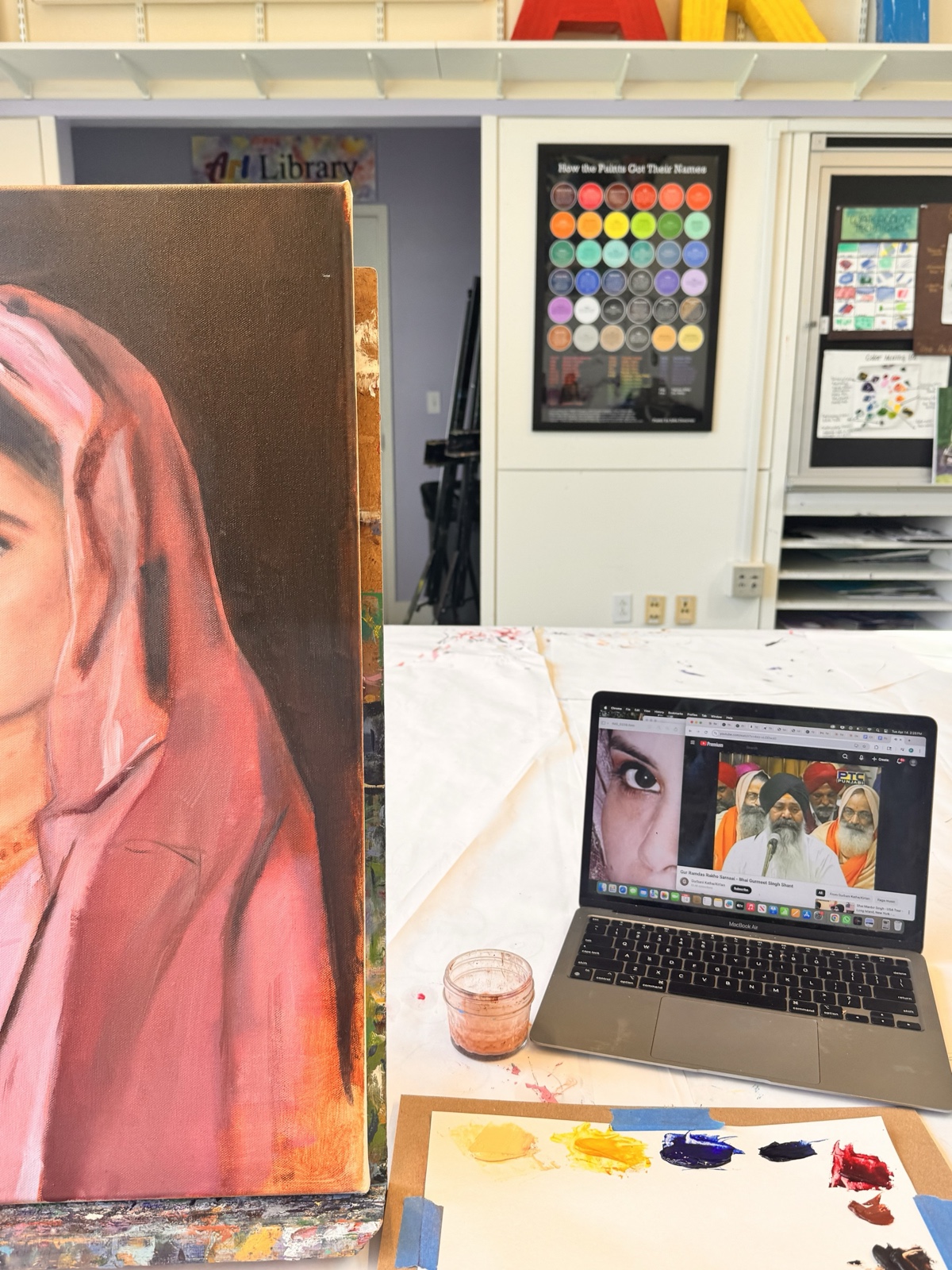 Painting set up in the studio with reference open on the laptop